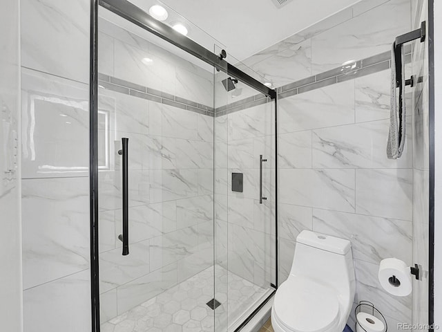 bathroom featuring toilet and a shower stall