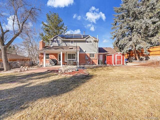 back of property featuring an outbuilding, brick siding, a patio area, a shed, and a fenced backyard