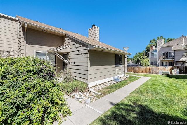 view of side of home with a yard