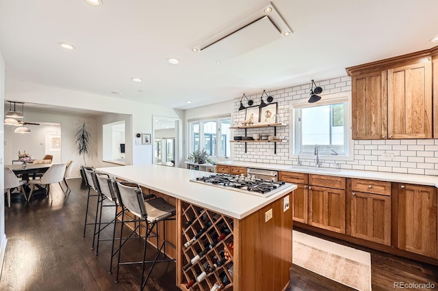 3695 E Dartmouth Ave, Denver, CO 80210 - kitchen with brown cabinets, light countertops, a kitchen breakfast bar, a kitchen island, and tasteful backsplash