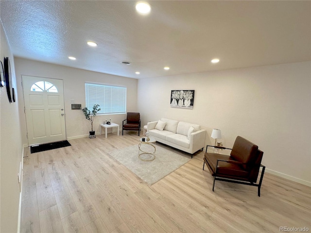 living room with light hardwood / wood-style flooring and a textured ceiling