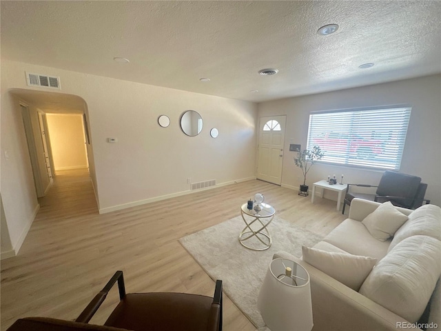 living room with light hardwood / wood-style floors and a textured ceiling