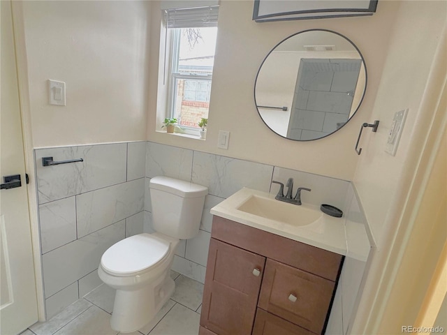 bathroom featuring vanity, tile walls, tile patterned floors, and toilet