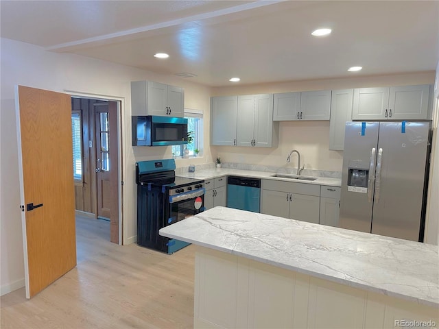 kitchen with sink, gray cabinets, light hardwood / wood-style floors, and appliances with stainless steel finishes