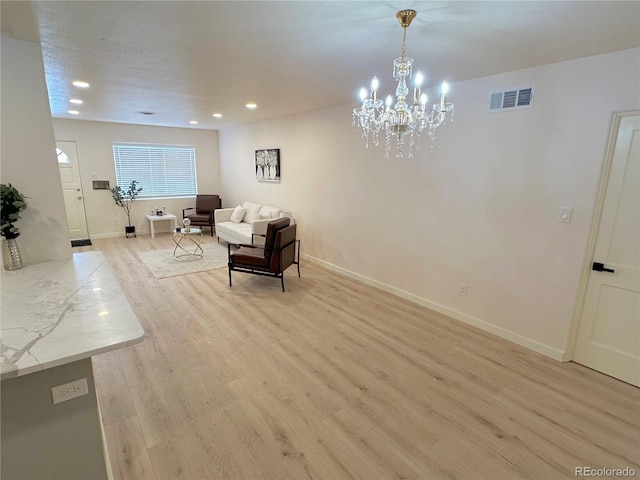 sitting room featuring an inviting chandelier and light hardwood / wood-style flooring