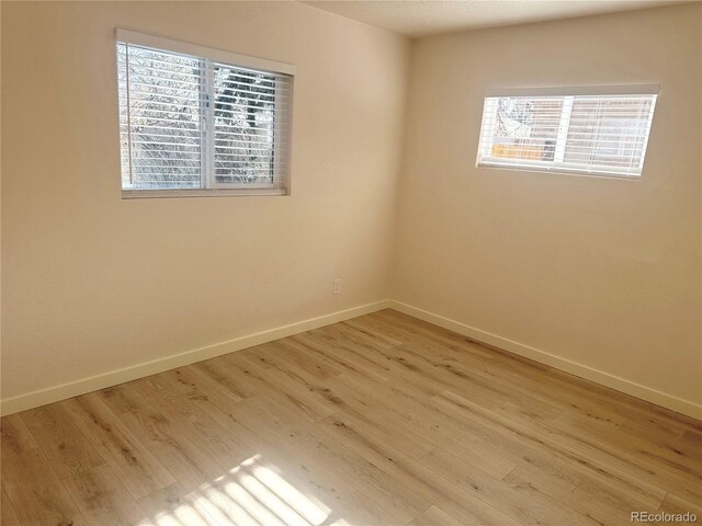 unfurnished room with a healthy amount of sunlight and light hardwood / wood-style flooring