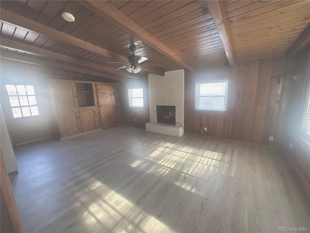 unfurnished living room featuring hardwood / wood-style floors, a fireplace, wooden ceiling, and beamed ceiling