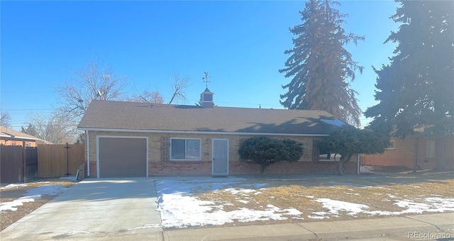 single story home with driveway, brick siding, an attached garage, and fence