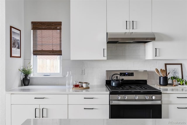 kitchen with white cabinetry, stainless steel gas range oven, and range hood