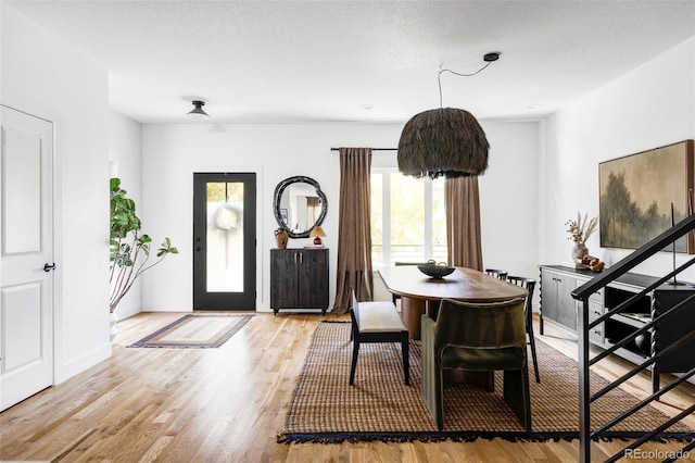 dining area featuring a textured ceiling and light hardwood / wood-style floors