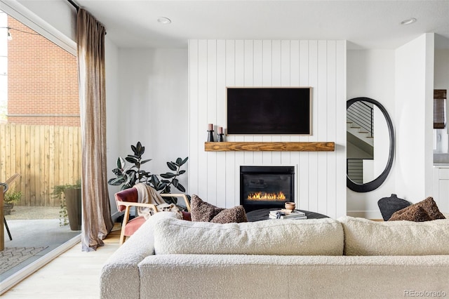 living room with hardwood / wood-style flooring and a large fireplace