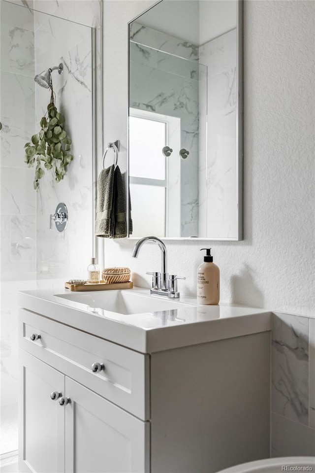 bathroom with vanity and tiled shower