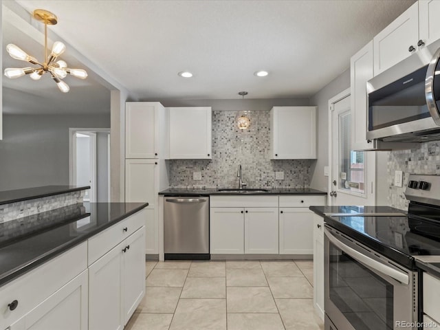 1785 Geneva St, Aurora, CO 80010 - kitchen featuring appliances with stainless steel finishes, a chandelier, dark countertops, backsplash, and recessed lighting