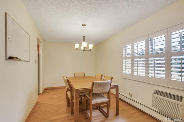 13952 E Marina Dr Unit 102, Aurora, CO 80014 - dining room with a baseboard heating unit, a chandelier, light wood finished floors, and a textured ceiling