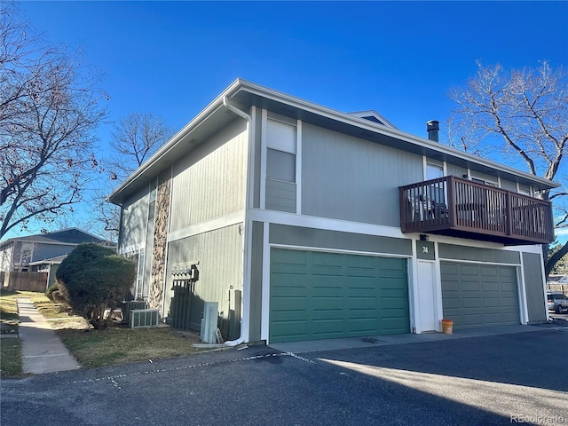 view of property exterior with a garage and a balcony