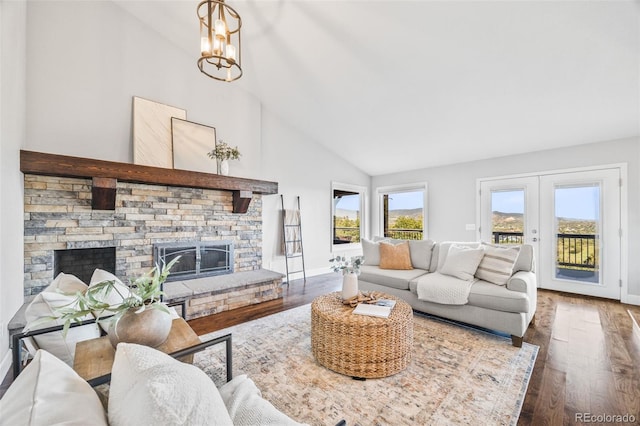 2357 Oak Ridge Rd, Sedalia, CO 80135 - living room with a stone fireplace, wood finished floors, high vaulted ceiling, french doors, and a chandelier