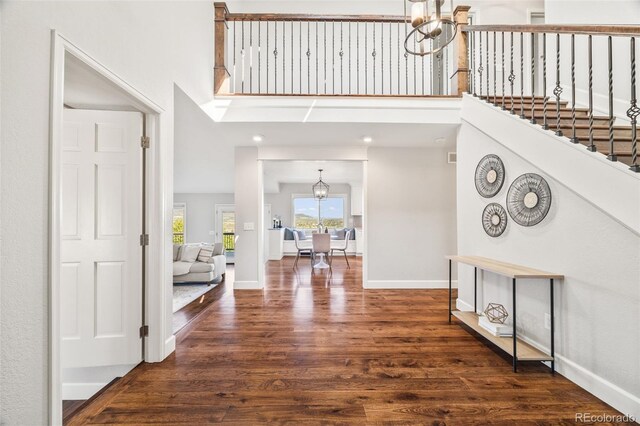 2357 Oak Ridge Rd, Sedalia, CO 80135 - entrance foyer with a chandelier, wood finished floors, a towering ceiling, and stairs