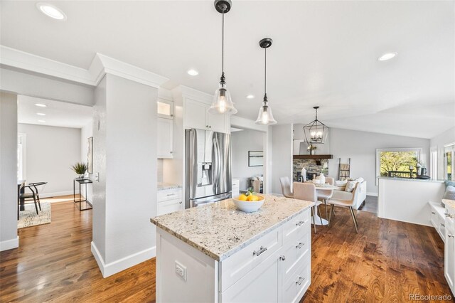 2357 Oak Ridge Rd, Sedalia, CO 80135 - kitchen featuring stainless steel fridge with ice dispenser, open floor plan, white cabinets, glass insert cabinets, and a kitchen island