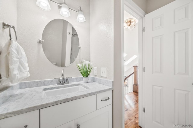 2357 Oak Ridge Rd, Sedalia, CO 80135 - bathroom featuring vanity, wood finished floors, and a textured wall