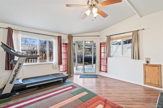 workout room featuring a ceiling fan, baseboards, vaulted ceiling, and wood finished floors