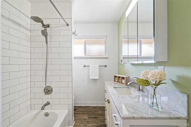 bathroom featuring shower / tub combination, plenty of natural light, wood finished floors, and vanity