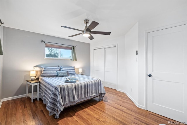 bedroom with a ceiling fan, baseboards, a closet, and wood finished floors