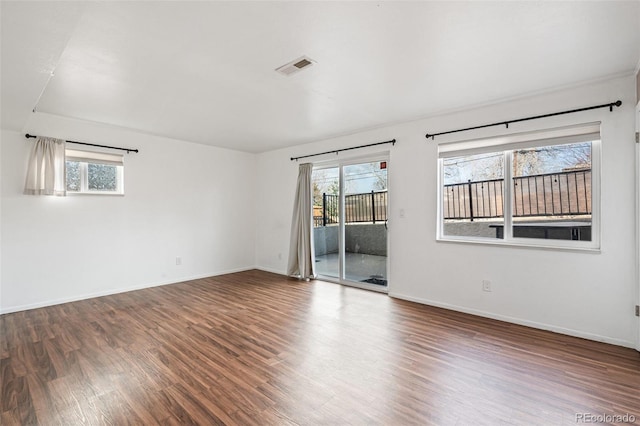 unfurnished room featuring visible vents, baseboards, and wood finished floors