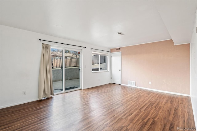 empty room with visible vents, baseboards, and wood finished floors