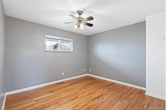 empty room with light wood-style floors, baseboards, visible vents, and a ceiling fan