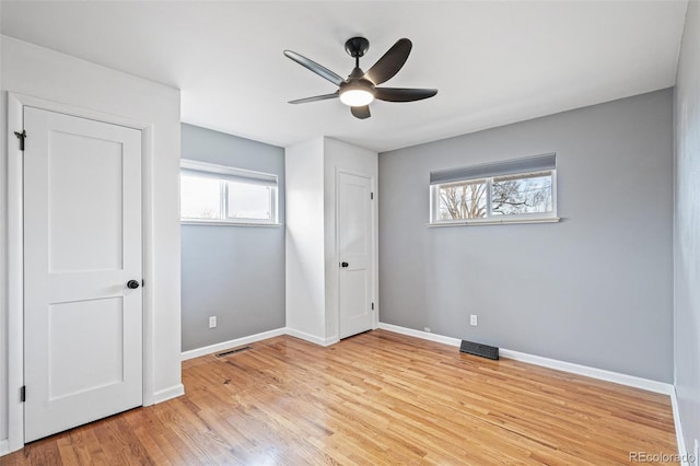 unfurnished bedroom with visible vents, ceiling fan, baseboards, and wood finished floors