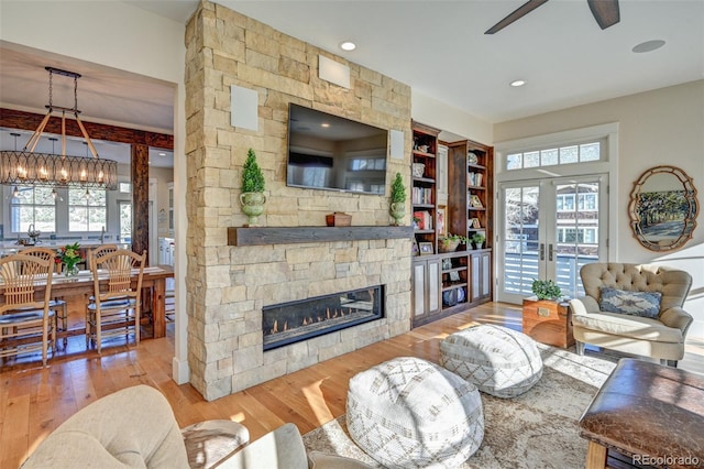 living room featuring a fireplace, hardwood / wood-style floors, french doors, and a healthy amount of sunlight