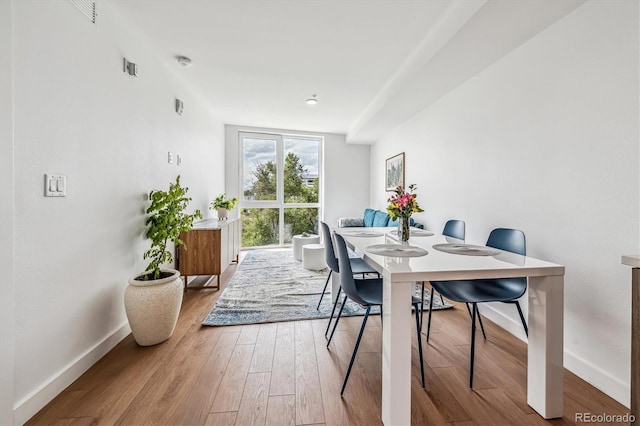 dining area with baseboards and wood finished floors