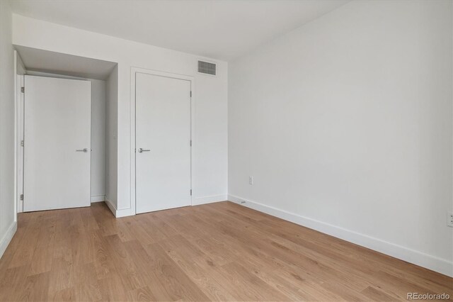 unfurnished bedroom featuring light wood-style flooring, visible vents, and baseboards