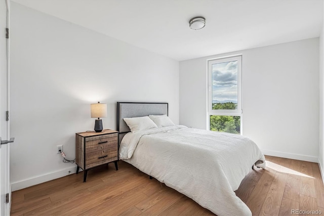 bedroom featuring baseboards and light wood-style floors