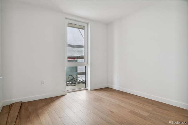 unfurnished room featuring light wood finished floors and baseboards
