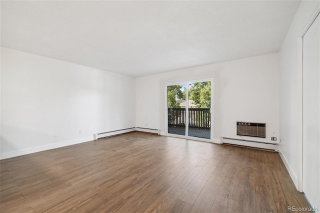 empty room featuring wood-type flooring, a wall unit AC, and a baseboard heating unit