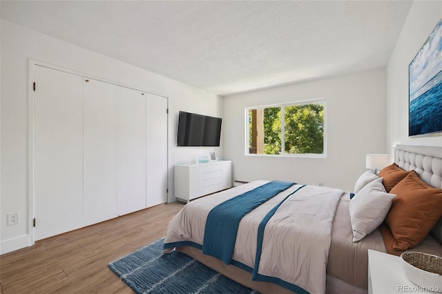 bedroom featuring a textured ceiling and light hardwood / wood-style floors