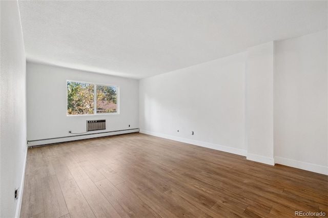 spare room with hardwood / wood-style flooring and a baseboard radiator