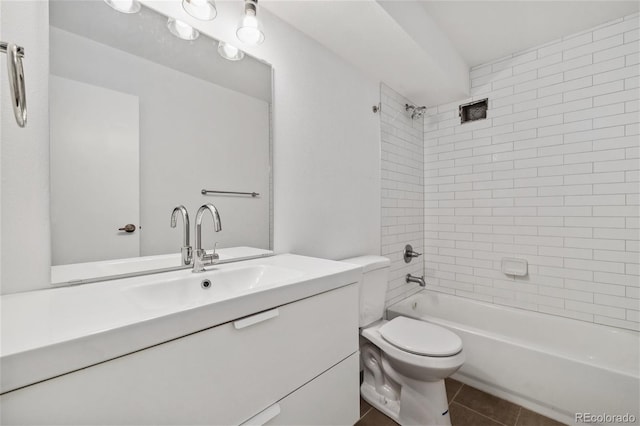 full bathroom with tile patterned flooring, vanity, tiled shower / bath combo, and toilet