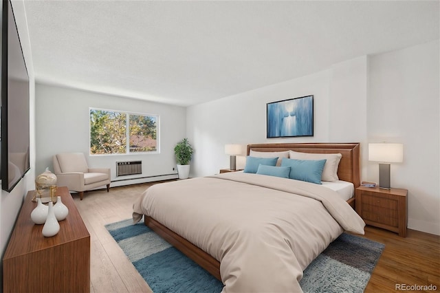 bedroom featuring hardwood / wood-style floors and baseboard heating