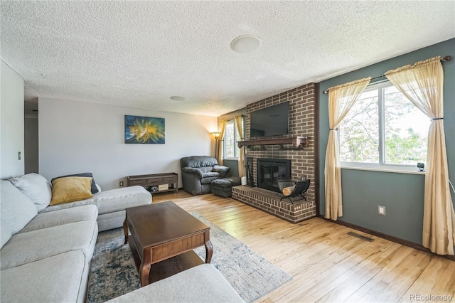8150 W Calhoun Dr, Littleton, CO 80123 - living room featuring hardwood / wood-style flooring, a textured ceiling, and a brick fireplace