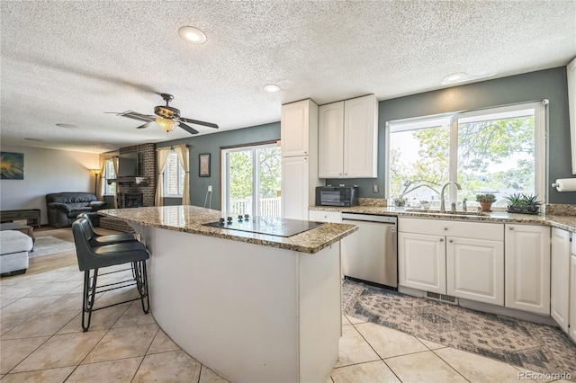 8150 W Calhoun Dr, Littleton, CO 80123 - kitchen featuring stainless steel dishwasher, black electric cooktop, a sink, a kitchen island, and light stone counters