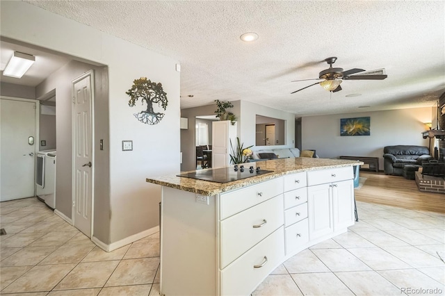 8150 W Calhoun Dr, Littleton, CO 80123 - kitchen with washer and clothes dryer, black electric stovetop, open floor plan, a textured ceiling, and a ceiling fan