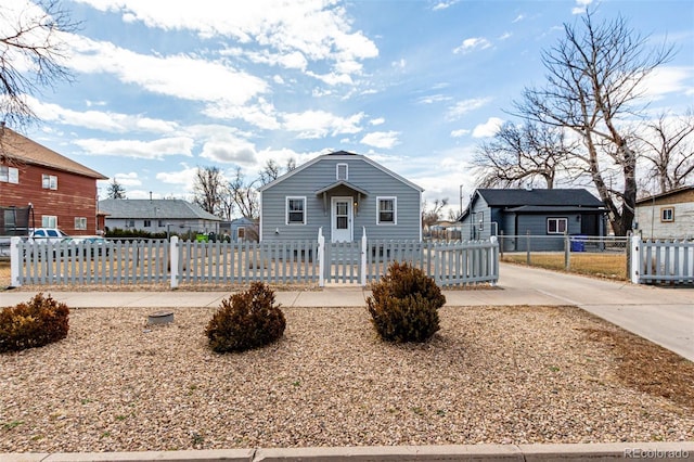 bungalow-style home featuring a fenced front yard, a residential view, and a gate