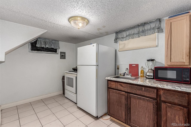 kitchen with light tile patterned floors, light countertops, a sink, a textured ceiling, and white appliances