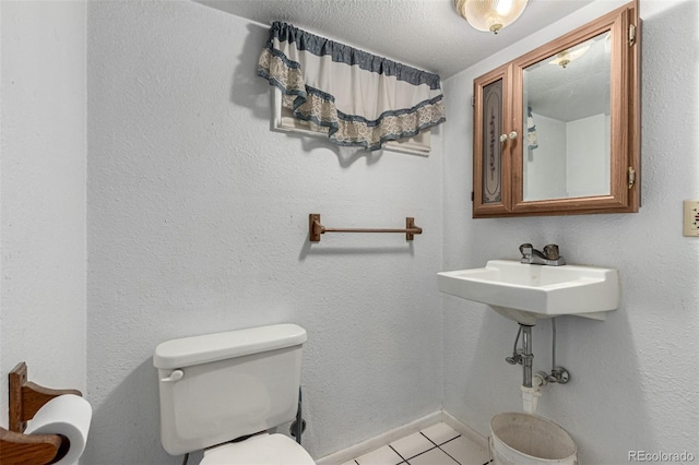 bathroom featuring toilet, tile patterned flooring, and baseboards