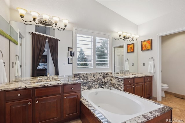 bathroom with toilet, lofted ceiling, two vanities, a bath, and a notable chandelier