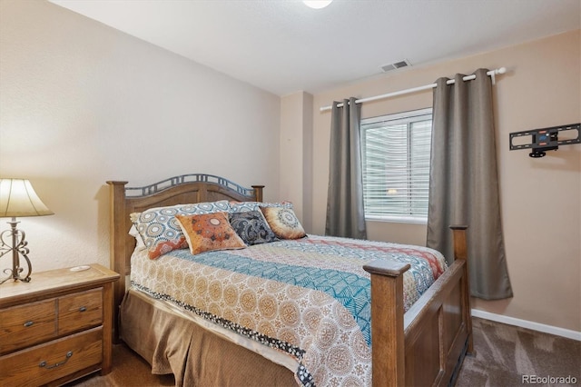 bedroom featuring visible vents, dark carpet, and baseboards