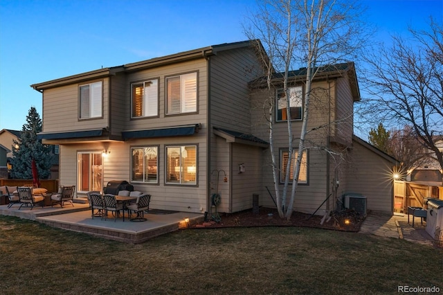 rear view of property featuring a yard, a patio, central AC, and fence