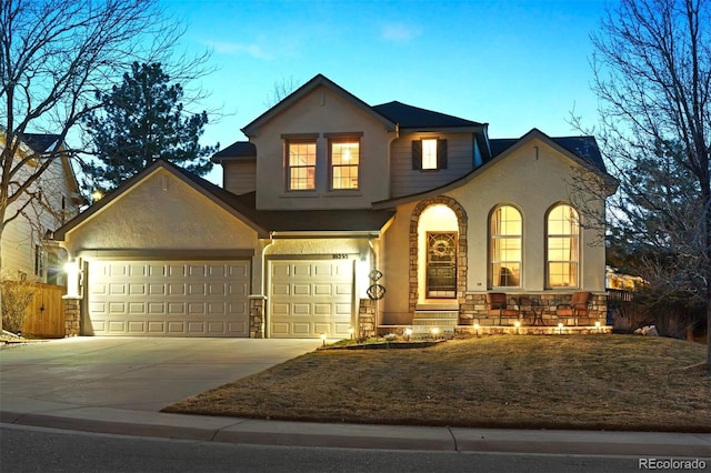 view of front facade featuring stucco siding, stone siding, covered porch, and concrete driveway